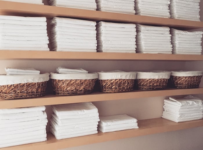 Shelves of white towels at Mantis Massage in Austin
