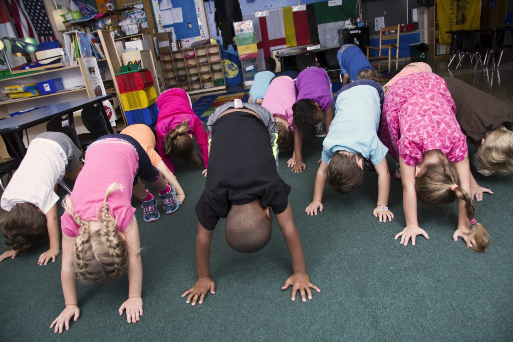 Pre-k students practicing mindful stretching